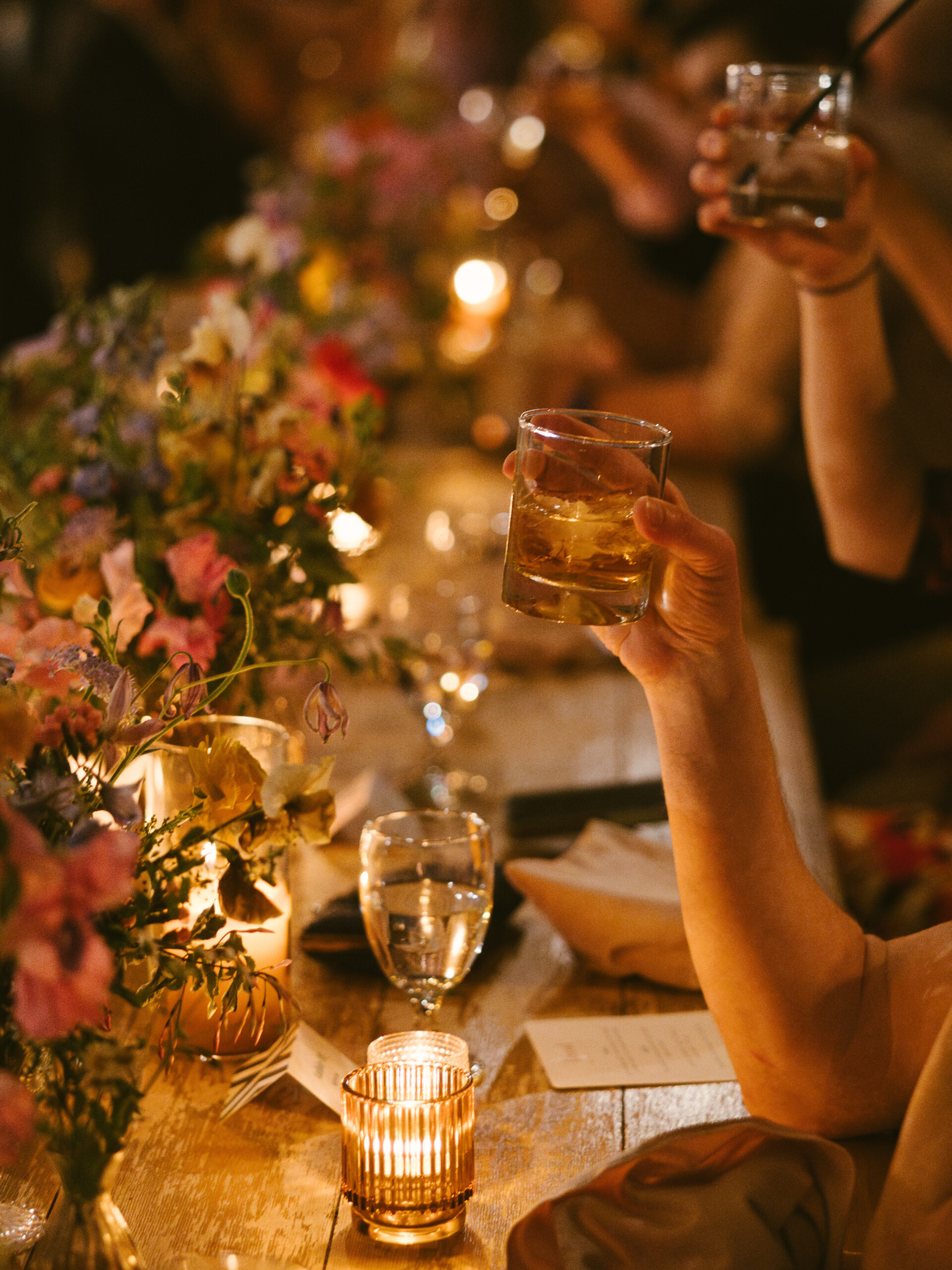 wedding guest cheersing at fig house los angeles warm and moody