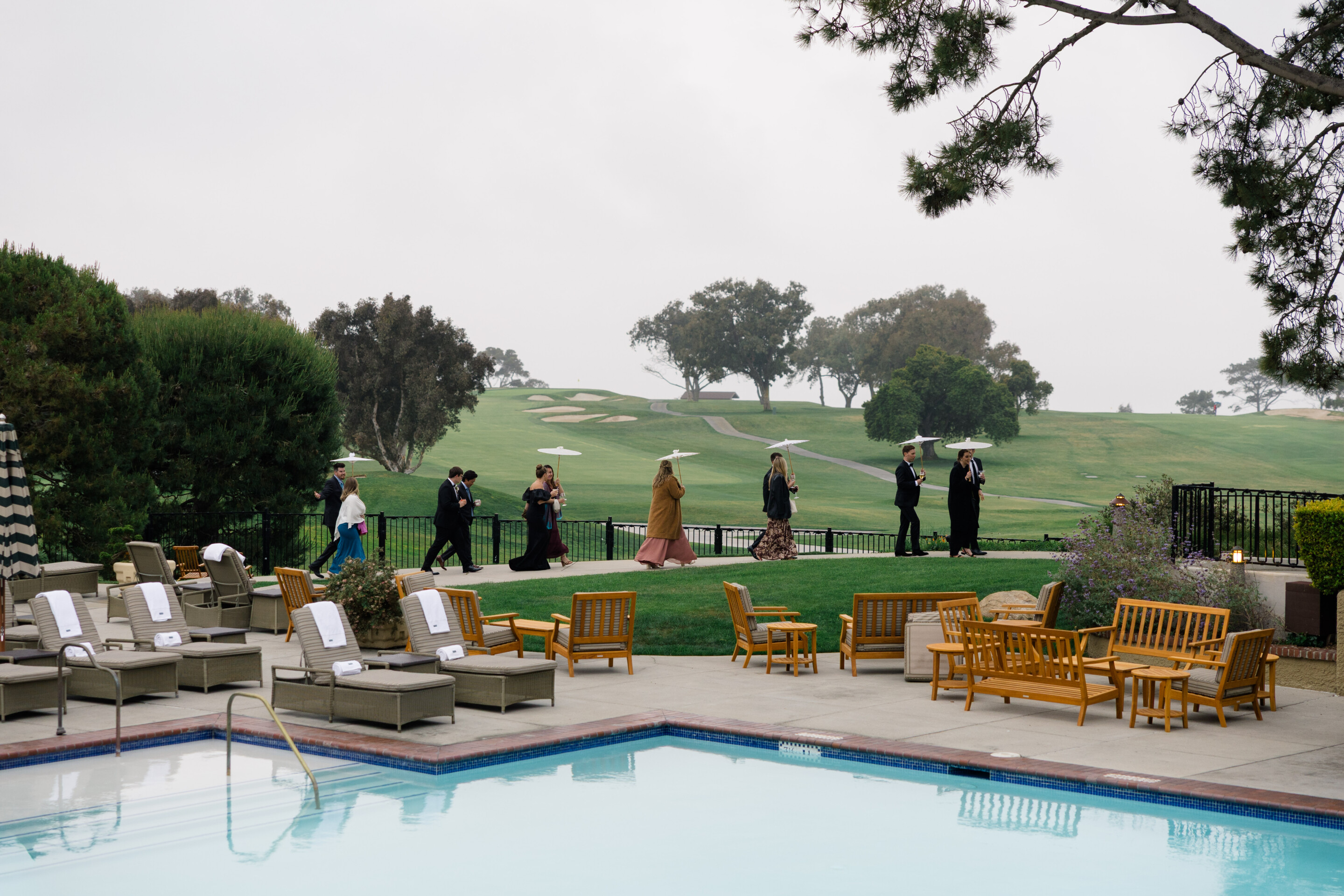 wedding guests walking with umbrellas in the rain at lodge at torrey pines la jolla california